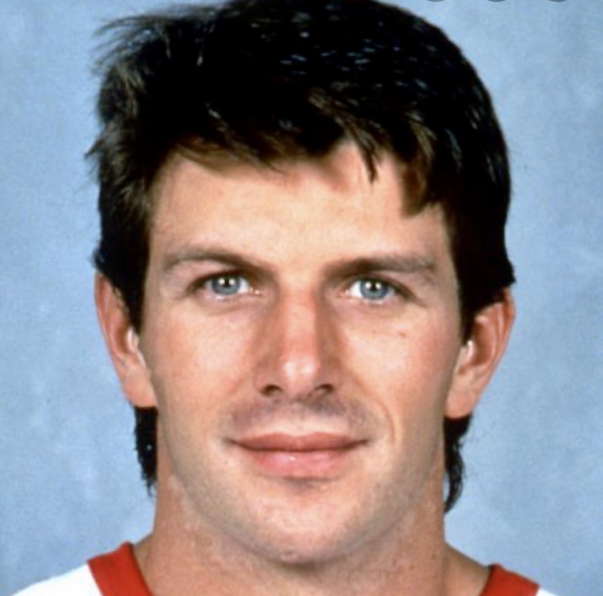 Une photo d’un joueur de hockey portant un maillot rouge, mettant en valeur l’essence du hockey.