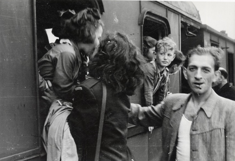 Un groupe de personnes debout à bord d'un train, plongés dans l'atmosphère vibrante de la Nouvelle Littérature.