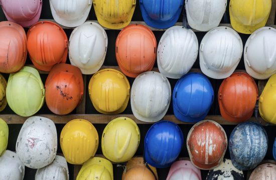 De nombreux casques de sécurité sont alignés sur un mur dans un chantier immobilier.