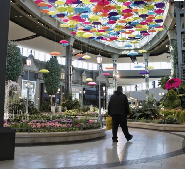 Ouverture des centres d'achats avec parasols colorés suspendus au plafond.