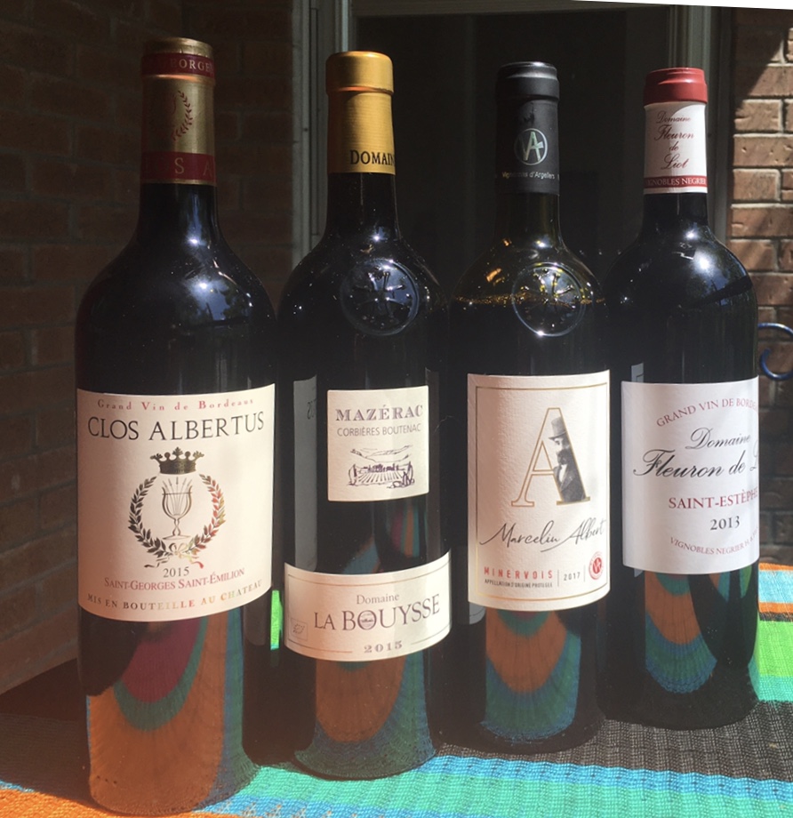 Quatre bouteilles de vin Vina sont alignées sur une table.