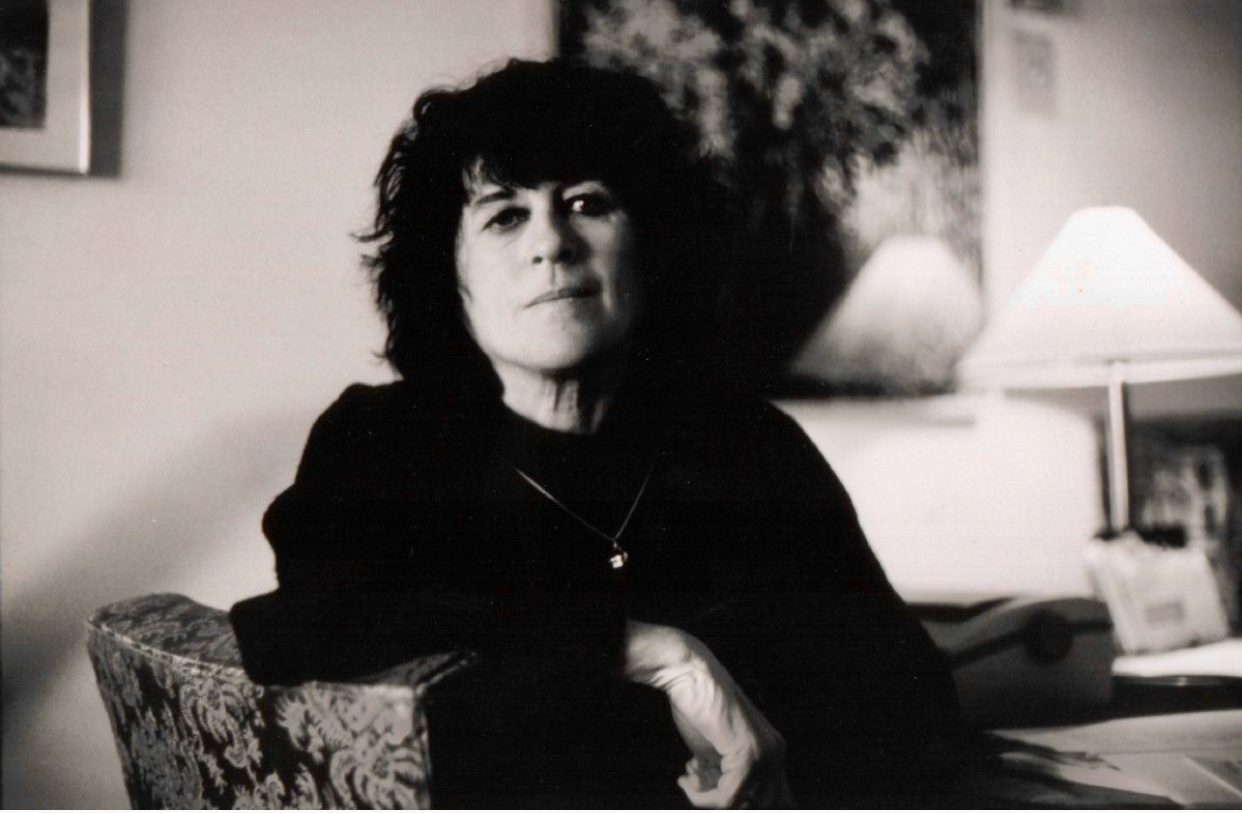 Une photo en noir et blanc d'inspiration littéraire représentant une femme gracieusement assise sur une chaise.