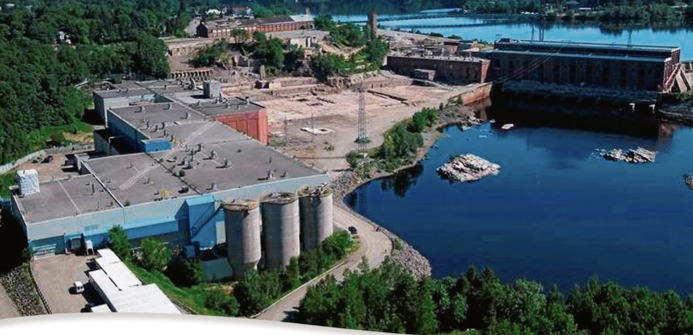 Vue aérienne d'une grande usine industrielle près d'une rivière, propriété des Actionnaires de Nemaska.