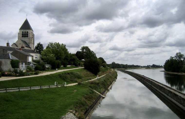 Une rivière en France à côté d'une église.