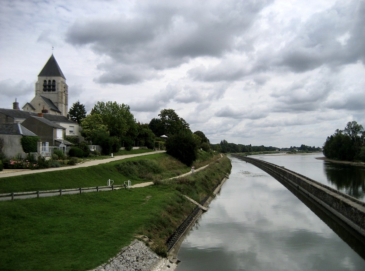 Une rivière en France à côté d'une église.