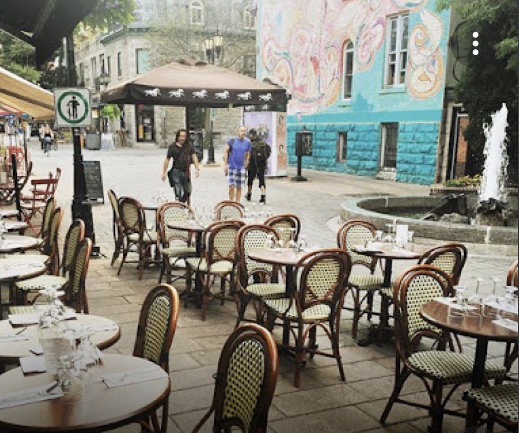Une scène Bistro à Montréal avec tables et chaises installées devant une fontaine.