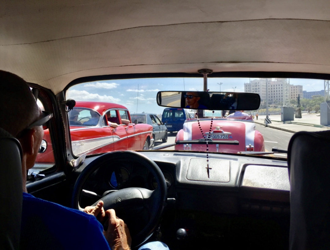 Un homme conduisant une voiture dans une rue de La Havane, Cuba.