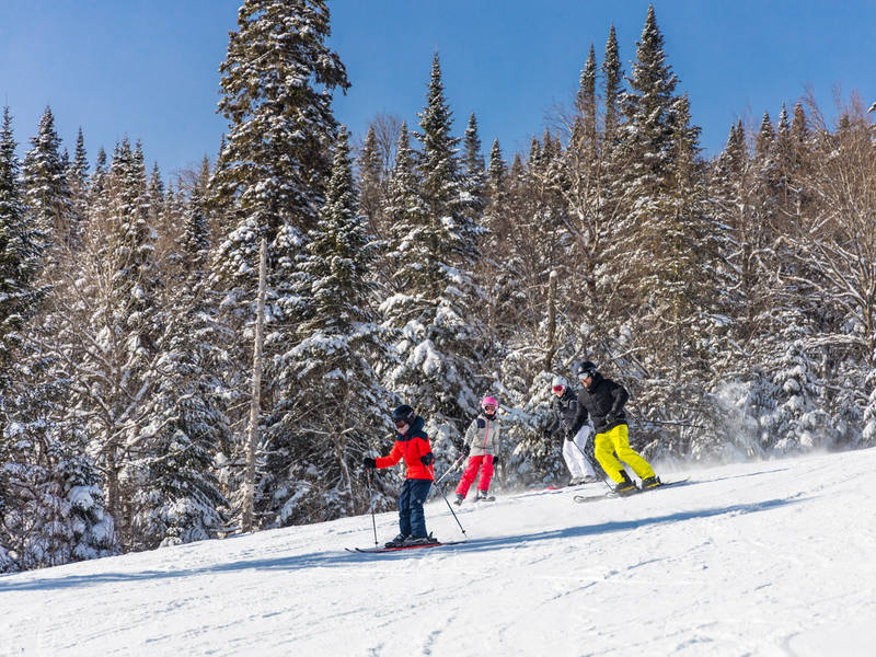 Un groupe de personnes skiant sur une pente enneigée.