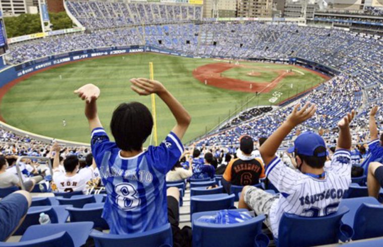 Un groupe de personnes regardant avec enthousiasme un match de baseball dans un stade, tout en adhérant aux protocoles de sécurité Covid.