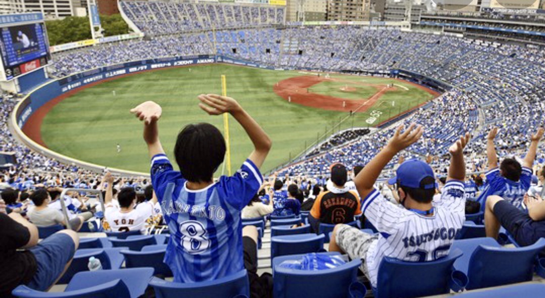 Un groupe de personnes regardant avec enthousiasme un match de baseball dans un stade, tout en adhérant aux protocoles de sécurité Covid.