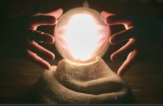 Une personne tient avec humour une boule de cristal lumineuse dans ses mains.