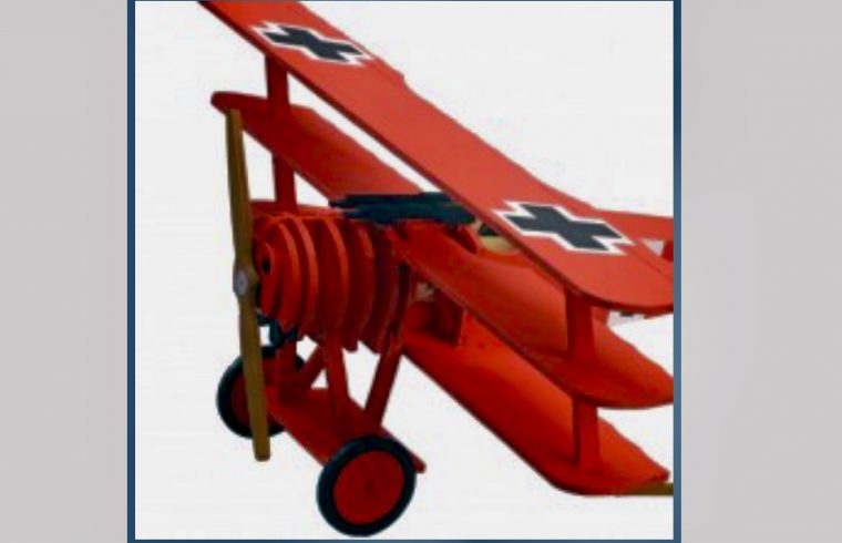 Un biplan rouge jouet volant dans une formation de pont aérien au-dessus de Berlin.