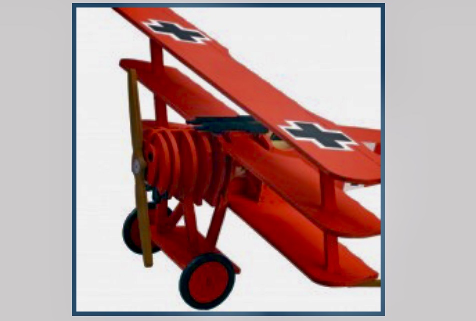 Un biplan rouge jouet volant dans une formation de pont aérien au-dessus de Berlin.