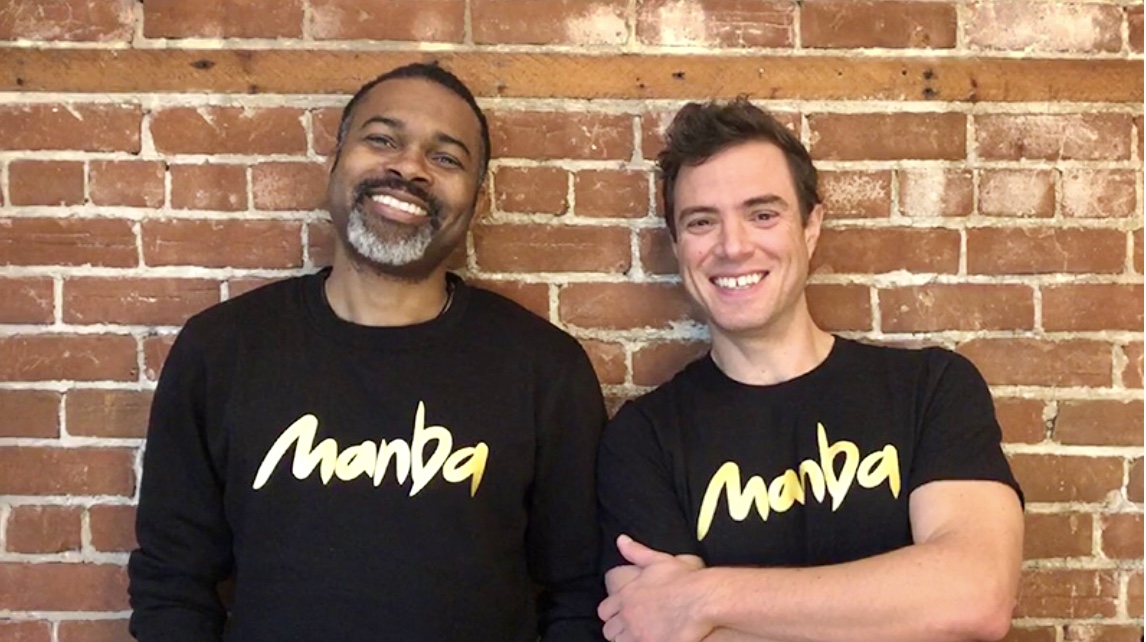 Deux hommes portant des t-shirts avec le mot namba, dégustant des collations au beurre d'arachide.