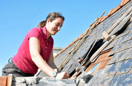 Une femme travaille sur un toit.