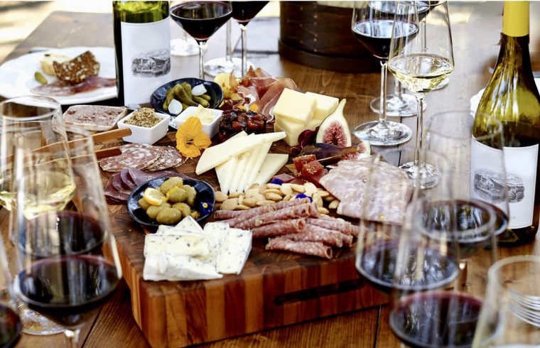 Un plateau de fromage DéziPpé et de vin sur une planche de bois au Salon des vins.