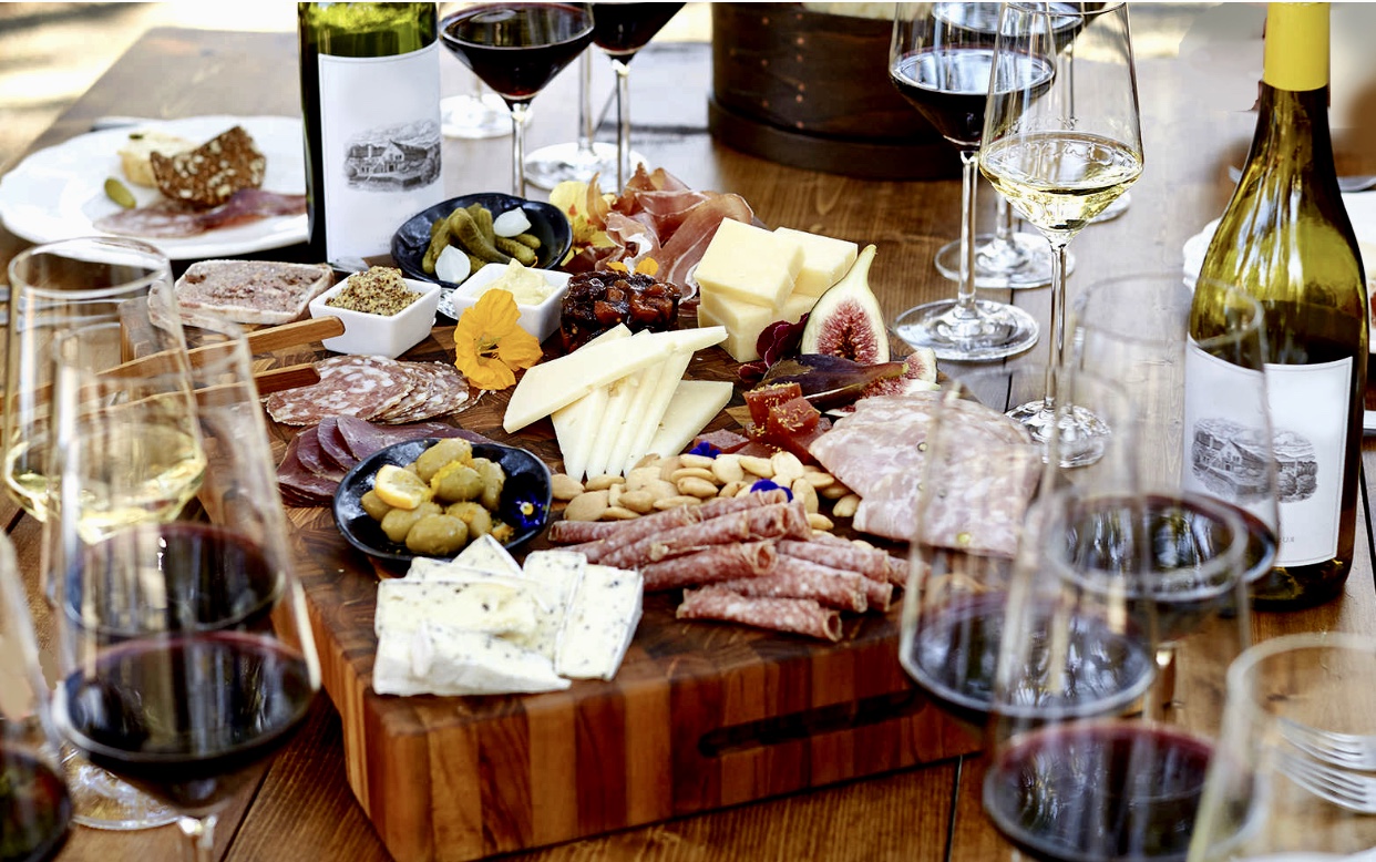 Un plateau de fromage DéziPpé et de vin sur une planche de bois au Salon des vins.