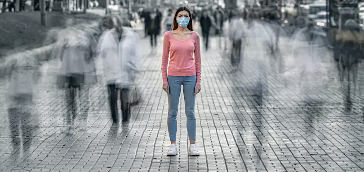Une femme portant un masque facial dans une rue, Fuite vers la campagne !