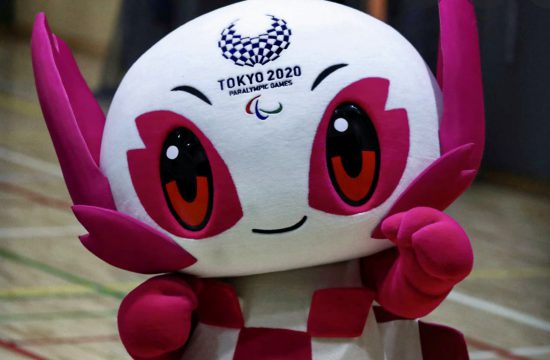 Une mascotte olympique rose et blanche se tient sur un terrain des Jeux olympiques 2021.