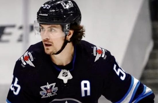 Un joueur de hockey portant un uniforme bleu est sur la glace.