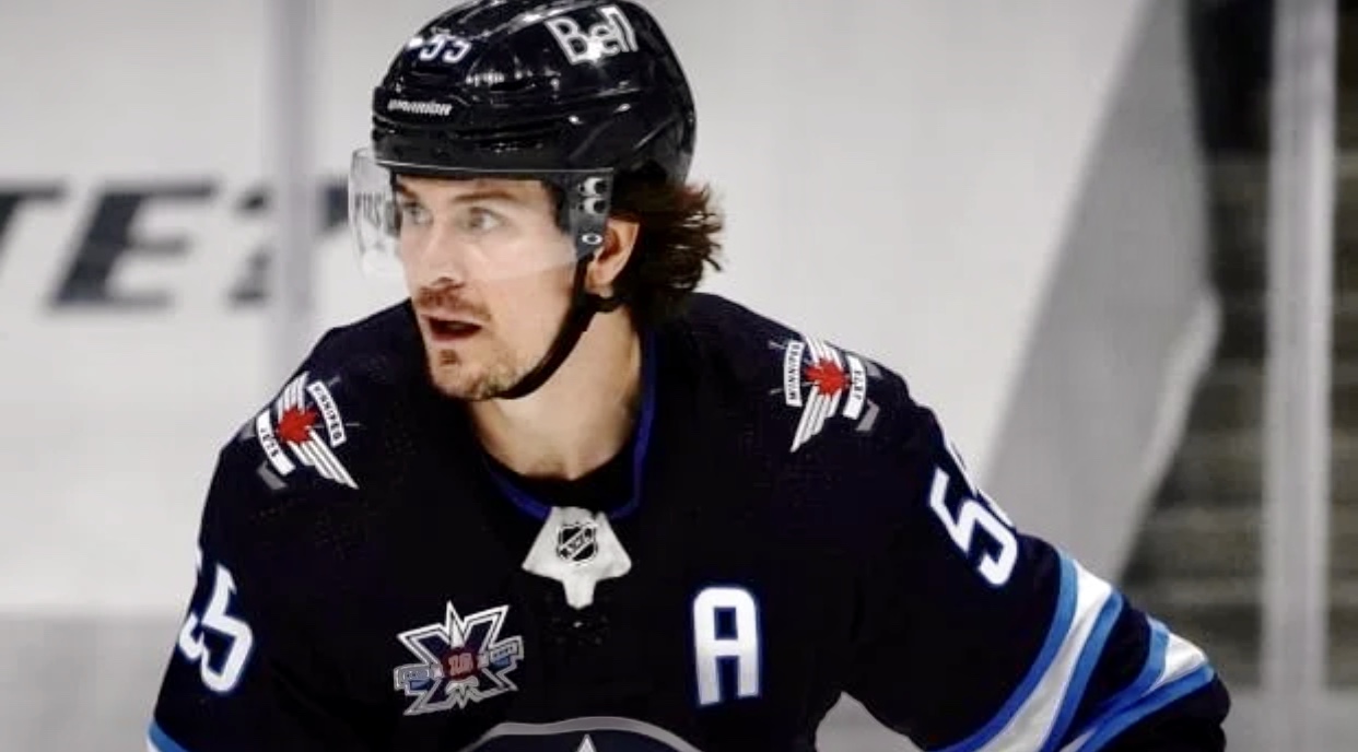 Un joueur de hockey portant un uniforme bleu est sur la glace.