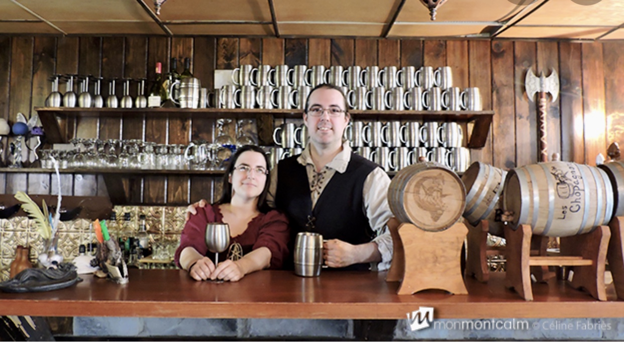 Un couple pose devant un bar médiéval à Québec.