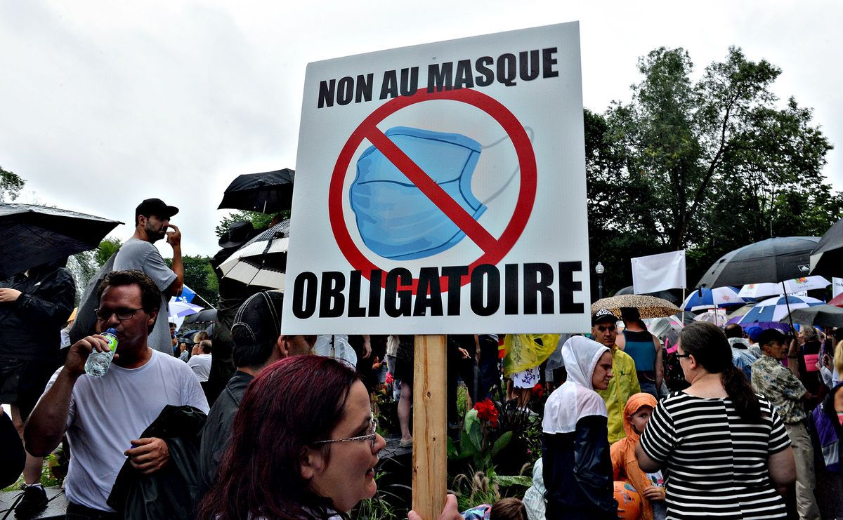 Un groupe de personnes tenant une pancarte indiquant qu'il n'y a pas de masque obligatoire, protestant contre les masques obligatoires (anti-masques) en réponse au Covid 19.
