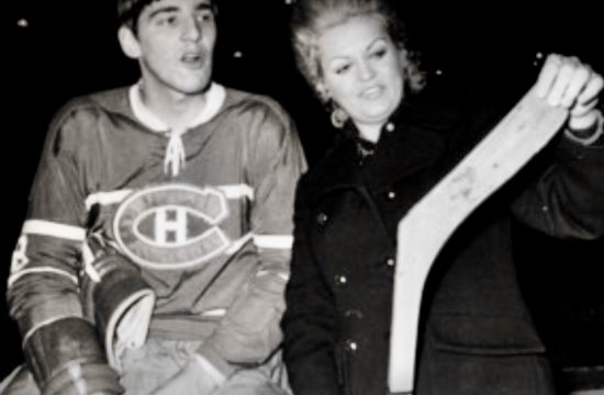 La Fille du Forum, une photo en noir et blanc d'un homme et d'une femme tenant un bâton de hockey.