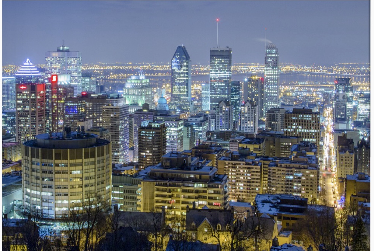 Toits de la ville de Montréal la nuit avec des lumières époustouflantes illuminant l'atmosphère urbaine.