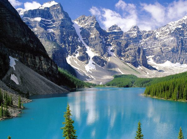 Un groupe de 18-44 ans se répartit en voyage pour profiter de la vue imprenable sur un lac bleu niché au milieu de montagnes majestueuses et d'arbres luxuriants.