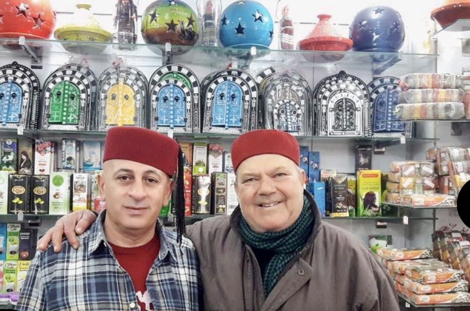 Deux hommes debout devant un magasin Tunisie.