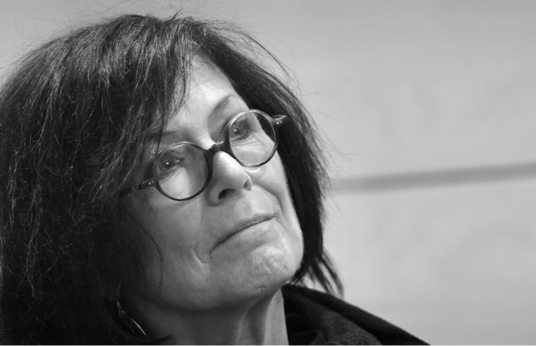 Une photo poétique en noir et blanc d’une femme à lunettes.