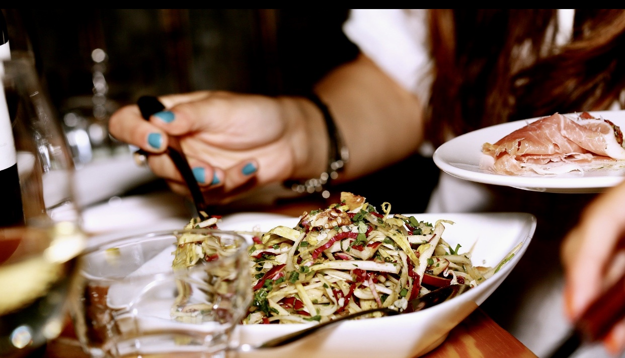 Une femme savoure une délicieuse assiette de nourriture dans un restaurant de Montréal.