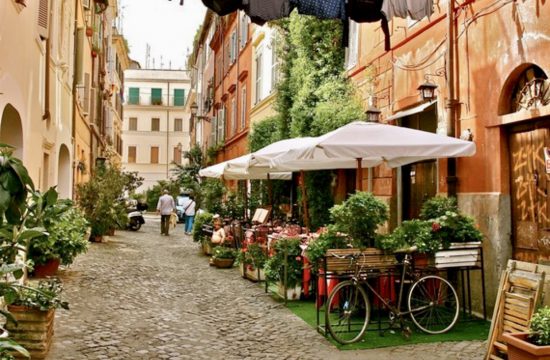 Une rue pavée de Rome ornée de plantes en pot.