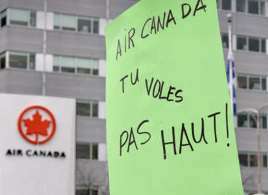 Un manifestant tient une pancarte indiquant air Canada da voules tu pas huit devant un, soulignant la forte présence du Français au Québec.