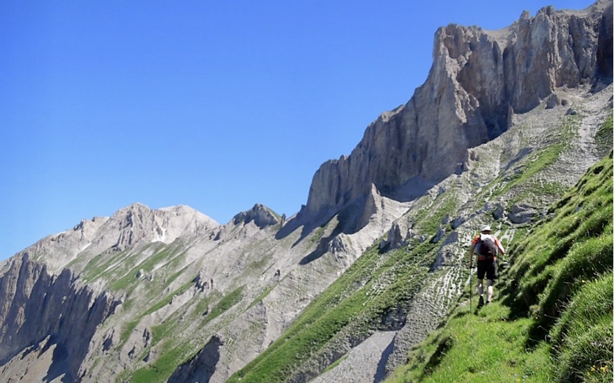 Un homme s'engage dans une randonnée philosophique sur un flanc de montagne escarpé.