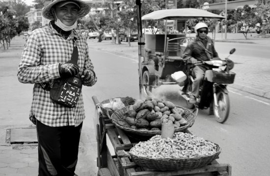 Un homme vendant des fruits dans une rue au Vietnam est capturé à travers l’objectif de la photographie.