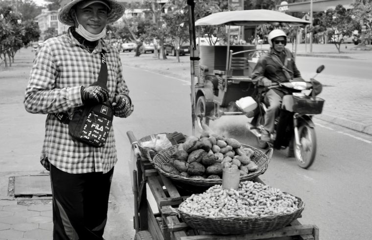 Un homme vendant des fruits dans une rue au Vietnam est capturé à travers l’objectif de la photographie.