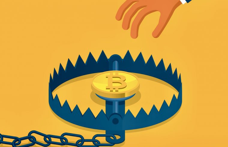 Une personne tient une chaîne contenant un bitcoin.