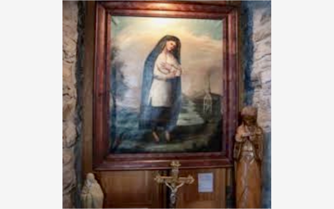 Un tableau religieux représentant la Vierge Marie est exposé dans une église.