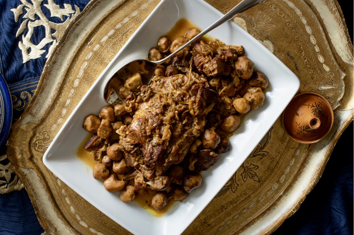 Une assiette de viande et de haricots sur une table, mettant en valeur les délicieuses saveurs des Recettes.