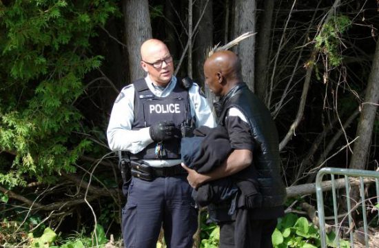 Deux policiers interrogent un homme dans les bois au sujet de l'immigration.