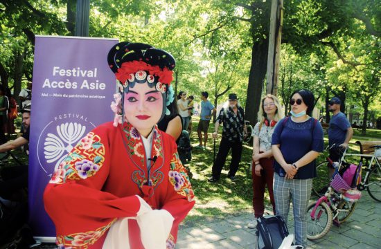 Une femme en costume chinois se tient devant un groupe de personnes au Festival Accès-Asie à Montréal.