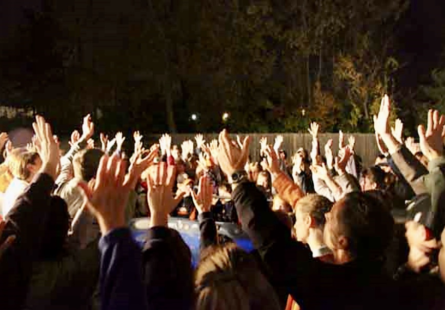 Une foule de gens engagés dans la philosophie, levant les mains en l'air.