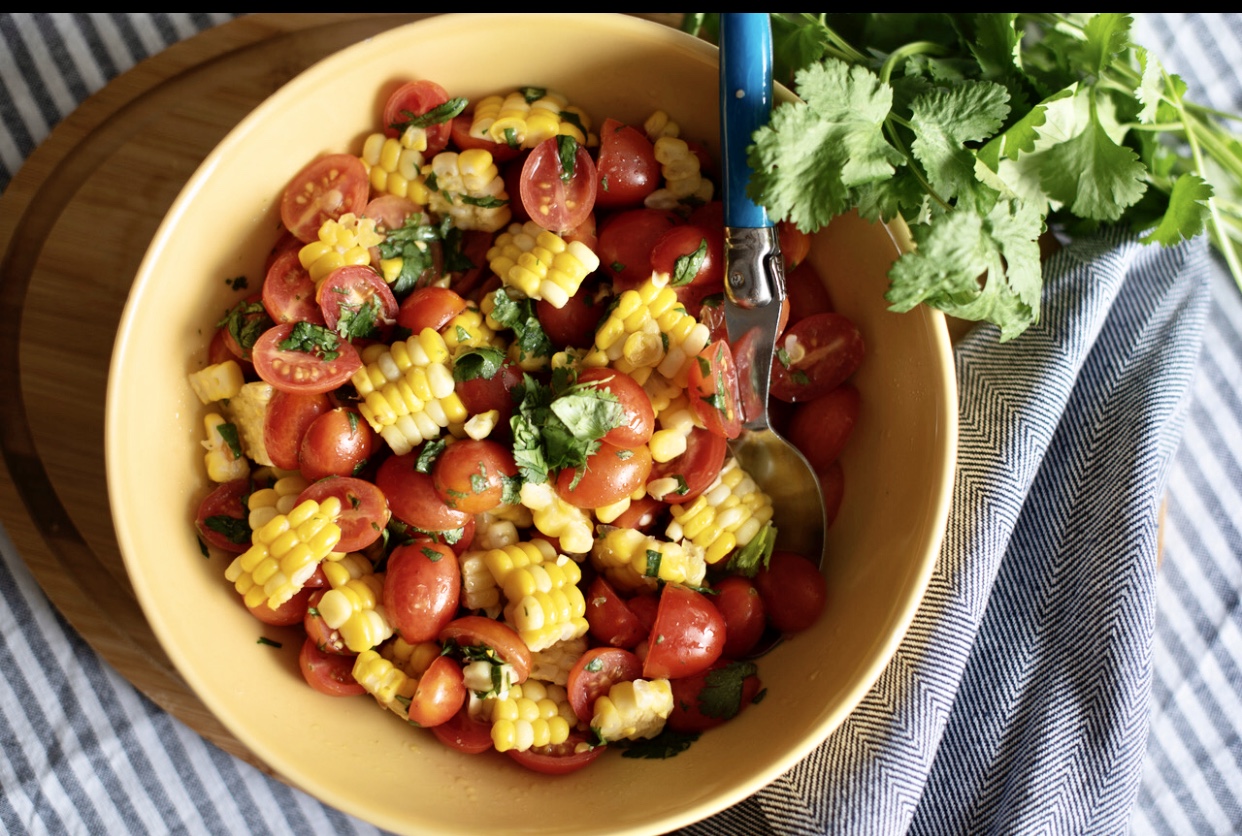 Un bol de salade de maïs avec tomates et coriandre. Recettes