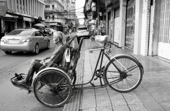 Un vieil homme faisant du vélo au Cambodge.