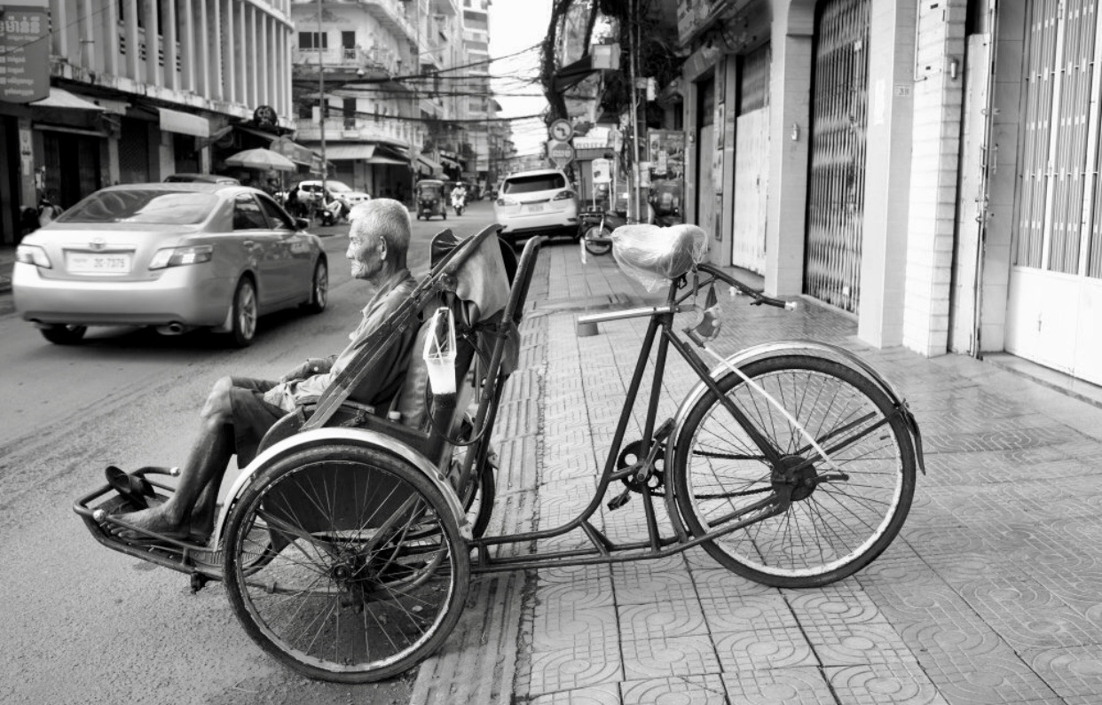 Un vieil homme faisant du vélo au Cambodge.