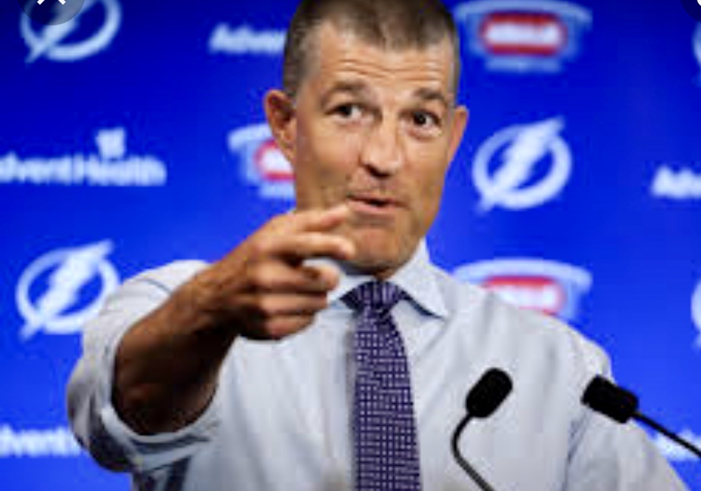 Mike Taylor, directeur général du Lightning de Tampa Bay, pointe un microphone lors d'une conférence de presse de hockey.