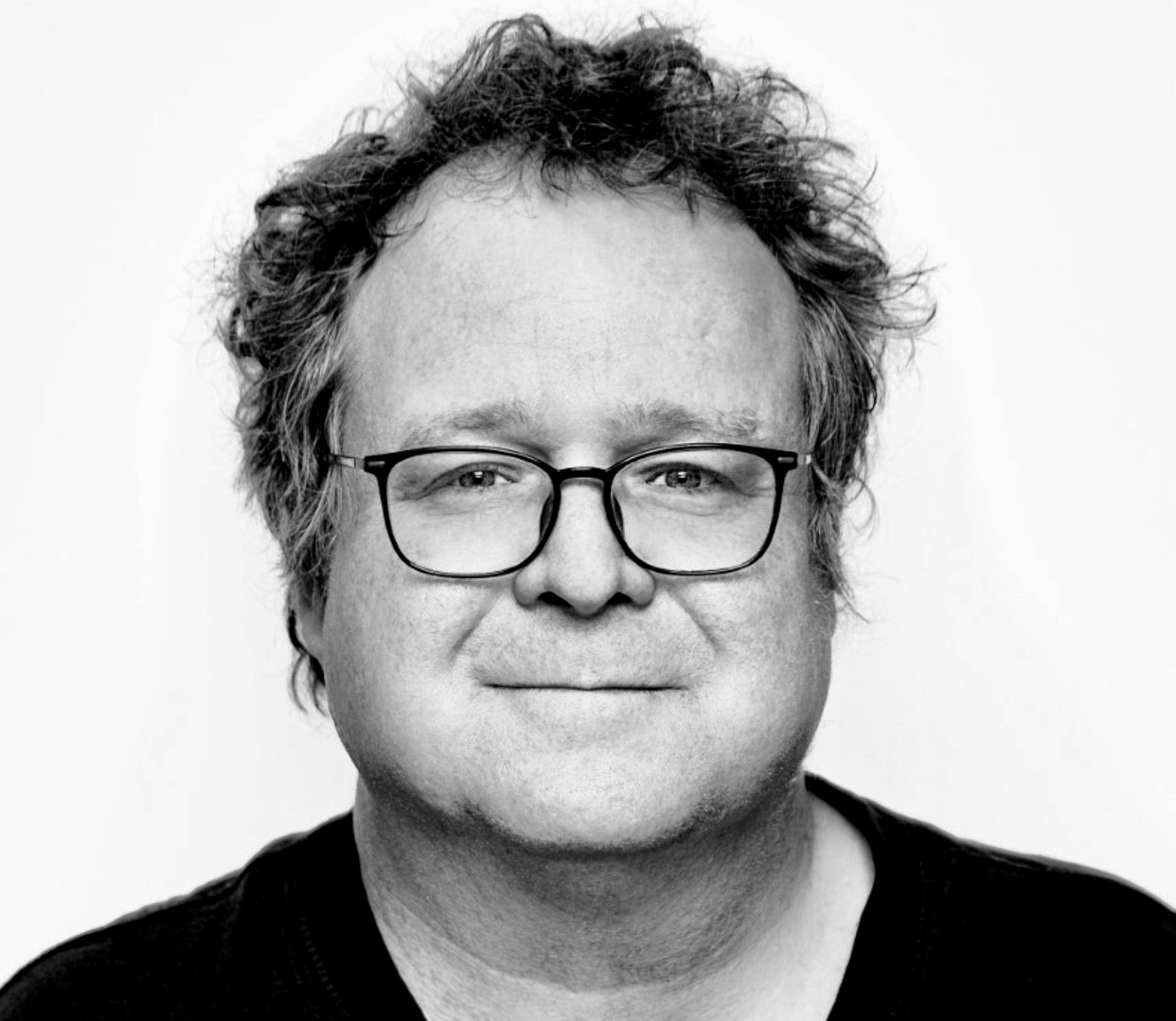 Une photo en noir et blanc d'un homme à lunettes, mettant en valeur l'essence de la Littérature québécoise.