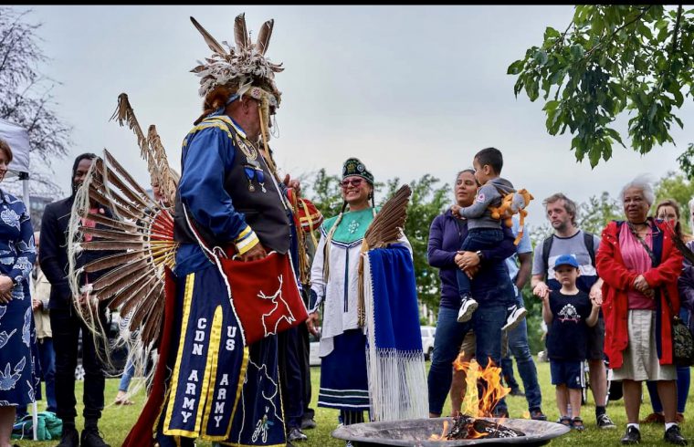 Un groupe d’Autochtones debout autour d’un feu.